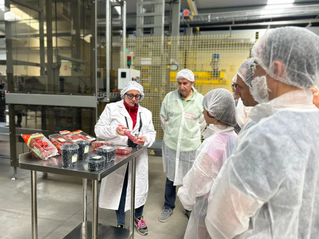 Mónica Loaiza, encargada del almacén, explicando a un grupo asistentes los tipos de formato de MUMU Berries en el II Día de la Familia & Amigos de El Pinar.